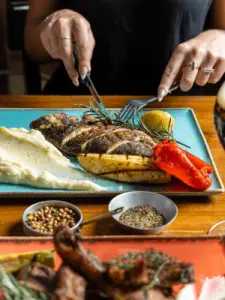 אדם חותך מנת דג שמוגשת במסעדת הדגים קורסר באשדוד